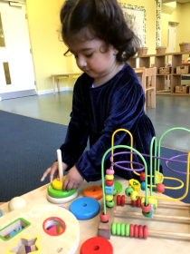 Child stacking colourful circles on a toy.