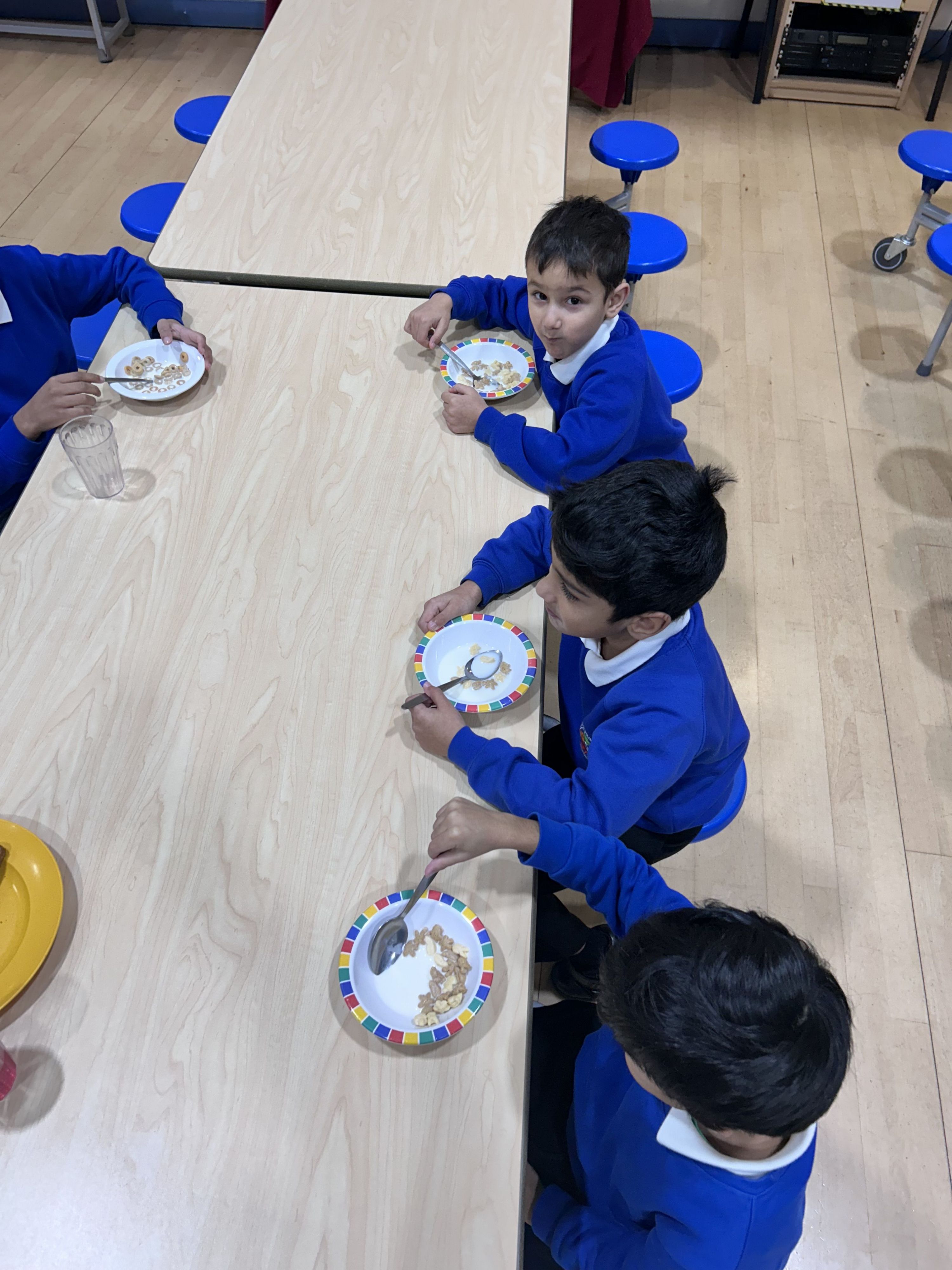 Children at tables eating cereal,